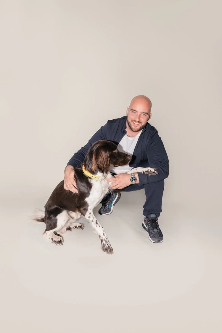 Man with a dog smiling at the camera