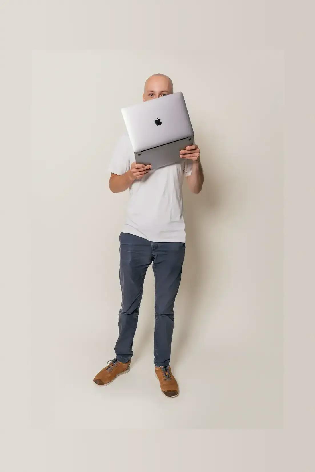 Picture of a men posing with a laptop.